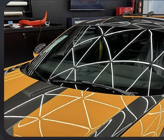 Detalhe do para-brisa após a aplicação da película em um carro amarelo.
